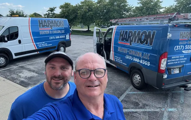 Jon and Justin Harmon in front of two Harmon Heating & Cooling service vans